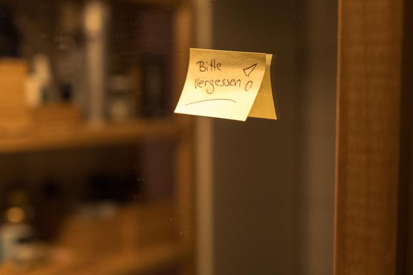 Post-it mit der Aufschrift "Bitte vergessen" an einem Spiegel