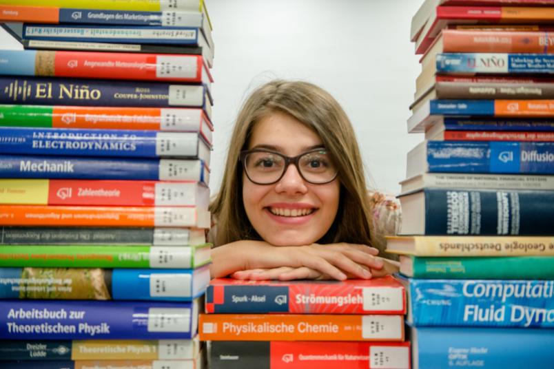 Studentin mit Buchstapel