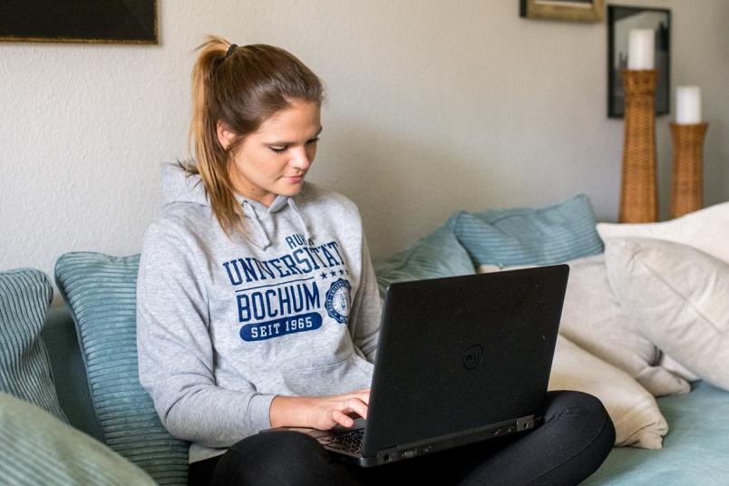 Studentin mit Laptop auf dem Schoß
