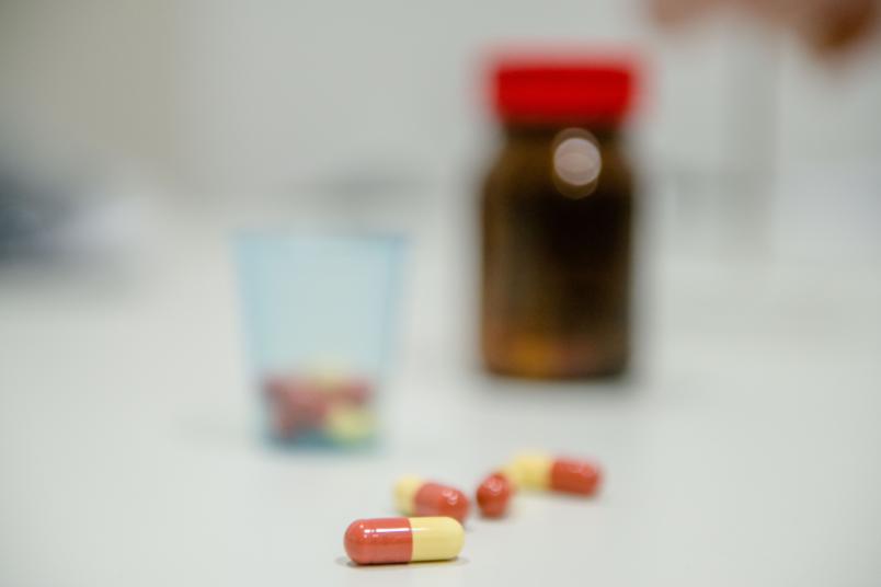 Bunte Tabletten vor einem Pillendöschen