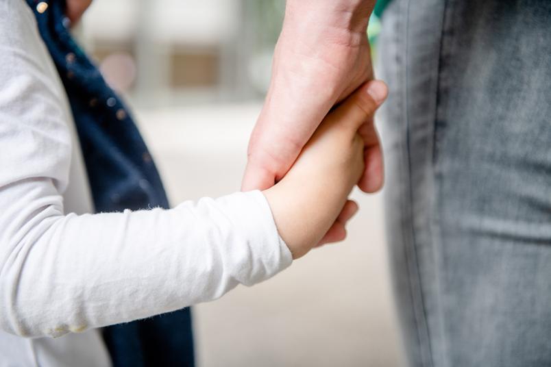 Kind und Mutter halten sich an Händen