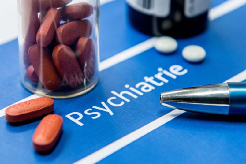 Tabletten auf einem Zettel mit der Aufschrift "Psychiatrie"