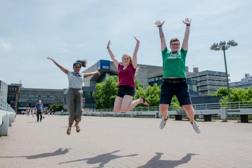 Studierende springen in die Luft.