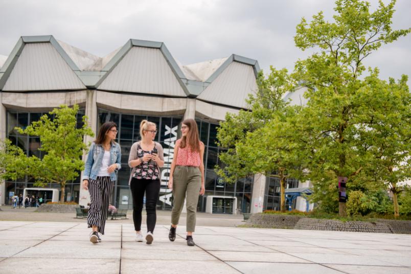 Studentinnen gehen über den Campus. 