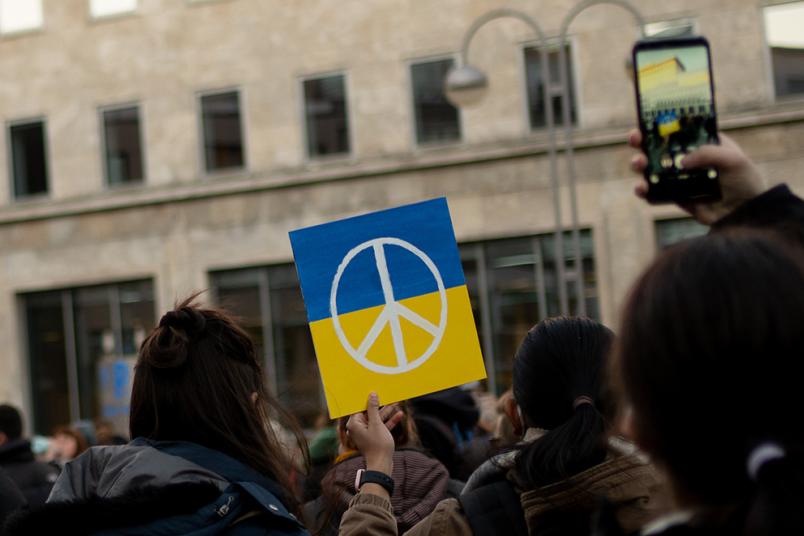 Demonstrierende Personen mit Ukraine-Flagge