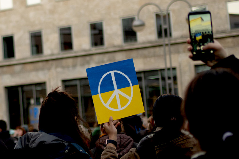 Demonstrierende Personen mit Ukraine-Flagge