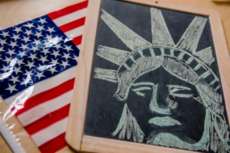 US-Flagge und Tafel mit Freiheitsstatue