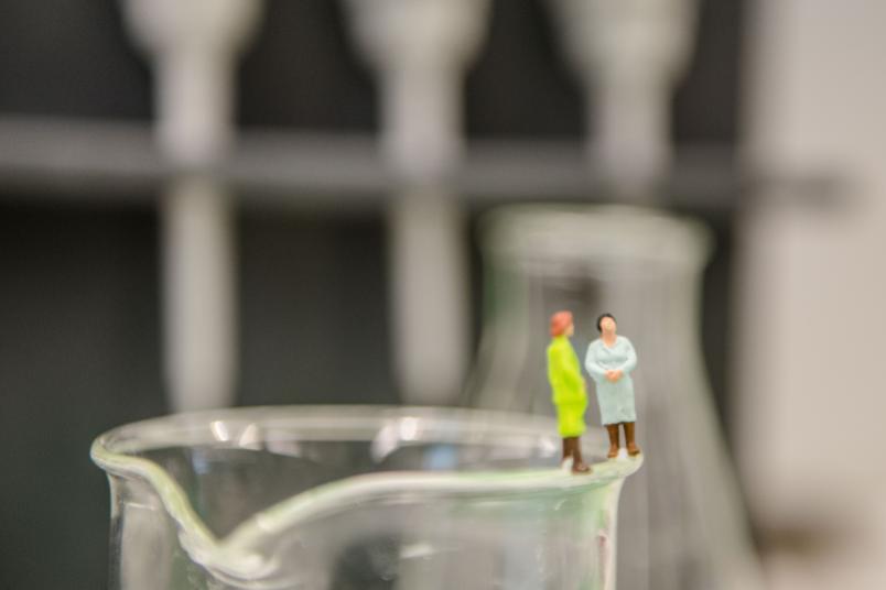 Zwei Minifiguren auf dem Rand eines Becherglases