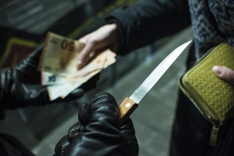 Messer bedroht Mensch, der Geld herausgibt