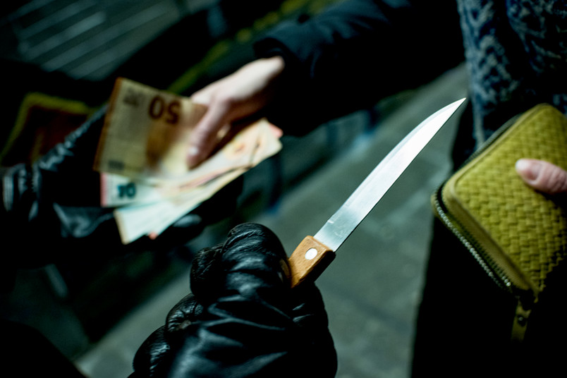 Messer bedroht Mensch, der Geld herausgibt