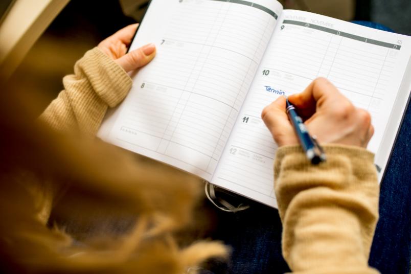 Frau trägt etwas in einen Kalender ein