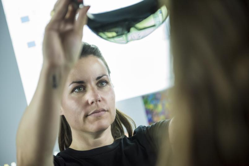 Eine Person setzt einer anderen eine Augmented-Reality-Brille auf.