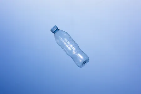Eine leere PET-Flasche vor einem blauen Hintergrund