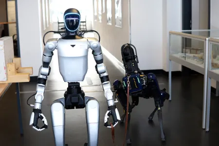 Ein humanoider Roboter hält einen hundeartigen Roboter an der Leine