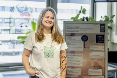 Eine junge Frau steht vor einem Poster